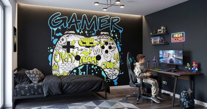Fototapeta gamingowa z padem i napisem GAMER na ścianie obok biurka w pokoju chłopca